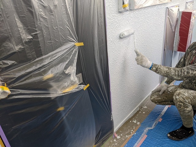 名古屋市北区 賃貸マンション共用廊下モルタル外壁塗装 「ハイパービルロックセラ」ローラー上塗り1回目 施工中
